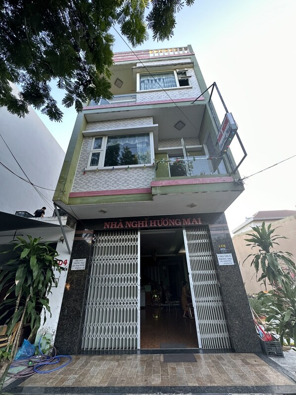 Um edifício de dois andares com uma placa que diz 'NHÃNG HÃUÃNG MAI'.