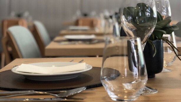 A restaurant setting with tables set for dining, featuring clear glassware and a potted plant. - Villa Rey Hotel & Spa (Vila de Rei)