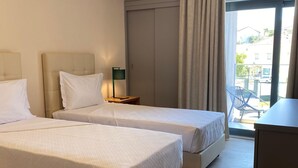 A hotel room with two beds, a desk, a chair, and a view of the outside. - Villa Rey Hotel & Spa (Vila de Rei)