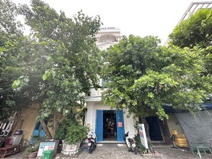 Um edifício com porta azul, uma motocicleta estacionada em frente e uma placa.