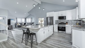 A spacious kitchen with a large island, white cabinetry, stainless steel appliances, and a modern pendant light fixture. - ~OPEN 9/14-17! Beachy Lagoon Getaway! Pool & Spa, Pets OK, Remodeled!~ (Carlsbad)