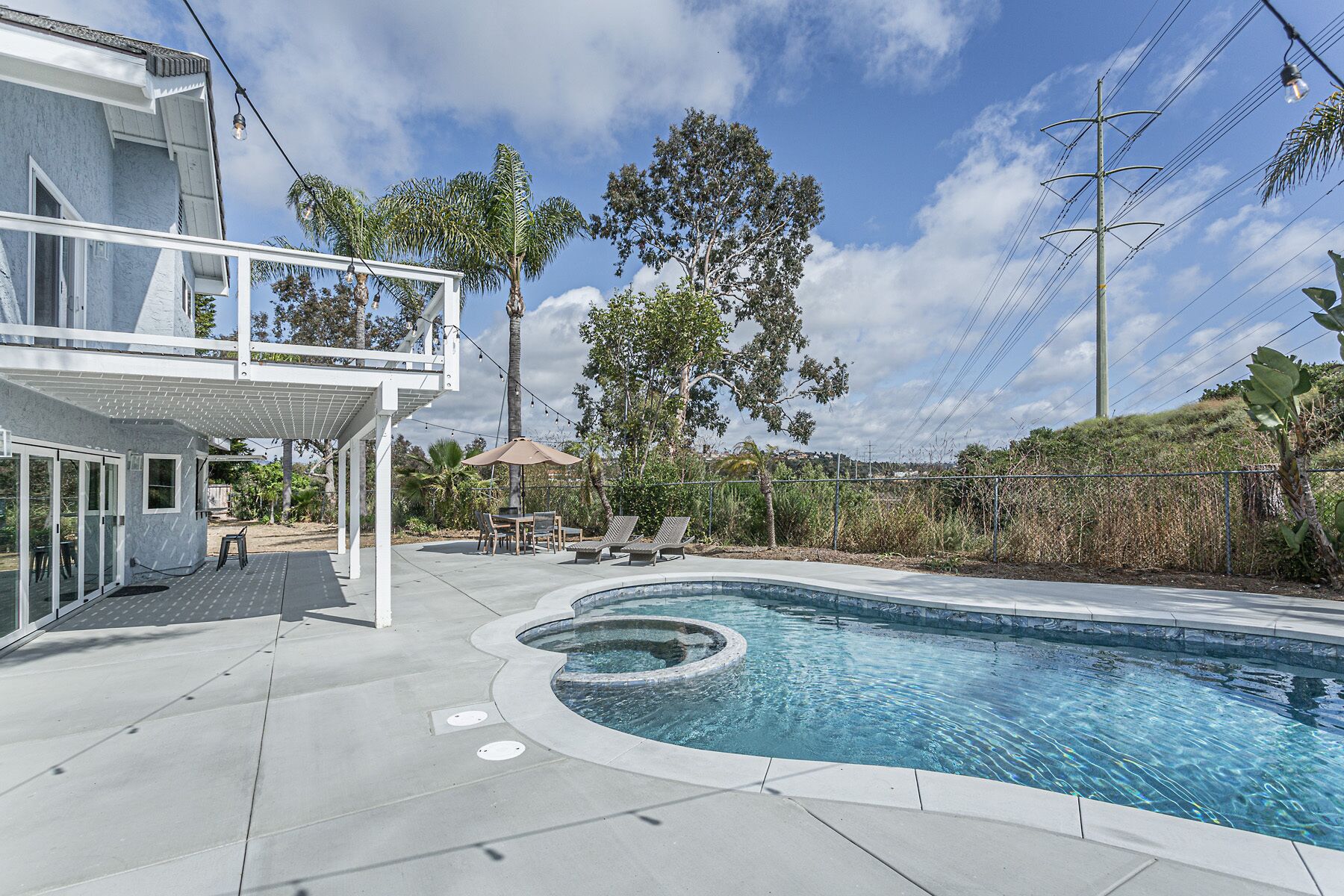 A modern house with a swimming pool, outdoor seating, and a pergola.
