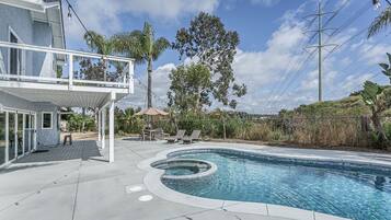 A modern house with a swimming pool, outdoor seating, and a pergola.