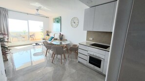 Cozinha moderna com área de refeições, ventilador de teto e vista para o exterior.