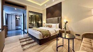 A modern hotel room with a large bed, a sitting area with a sofa and a small table, and a separate bathroom visible through a glass door. - Fortune Ranjit Vihar, Amritsar - Member ITC Hotels' Group (Amritsar)