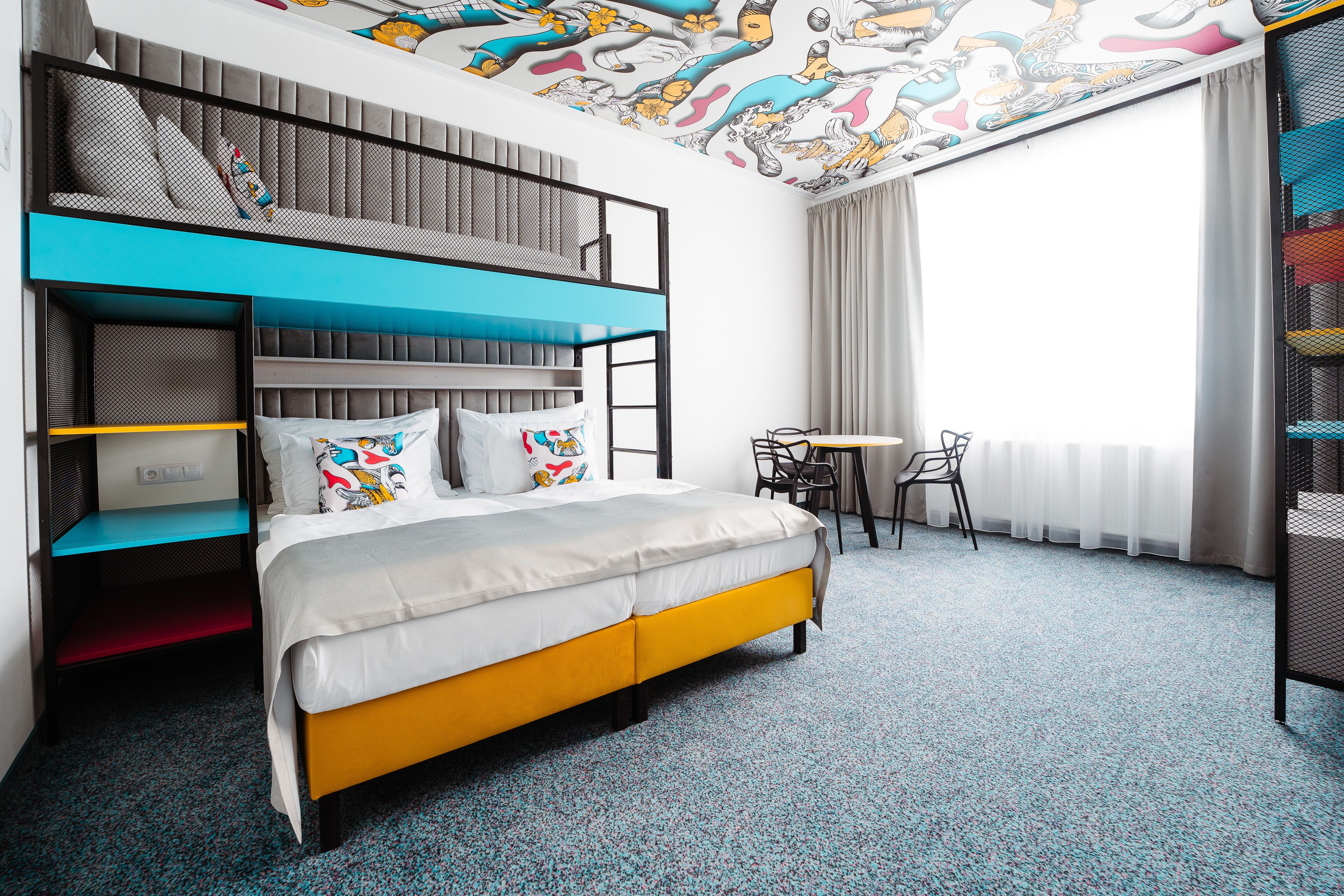 Ein Zimmer mit einem Etagenbett, einem Schreibtisch und einem Stuhl.