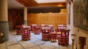 Una habitación con muebles de estilo tradicional, suelo de baldosas y un separador de madera con diseños elaborados.