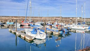 A marina with various boats docked, a clear sky, and a stone wall in the background. - 3 bedroom accommodation in Fraserburgh (Fraserburgh)