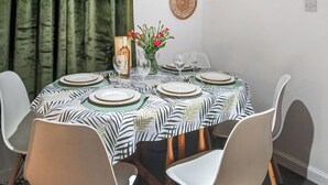 A dining table set with plates, glasses, and a vase of flowers. - 3 bedroom accommodation in Fraserburgh (Fraserburgh)