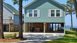 A two-story house with a covered porch and a view of the water. -  WATERFRONT Property on KDH Bike Path with water access, bikes, kayak, and canoe (Kill Devil Hills)