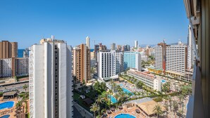 Un hotel moderno de gran altura con varias plantas, una piscina en la azotea y vistas panorámicas de la ciudad.