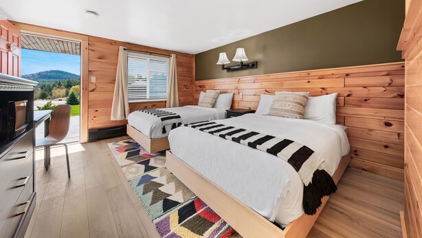 Un dormitorio con dos camas, un escritorio y una silla.