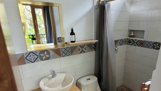 Une salle de bain équipée d’un lavabo, de toilettes et d’une douche.