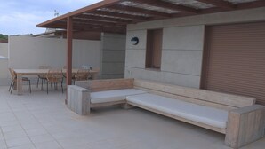An outdoor patio with a wooden bench, a table, and chairs. - Apartamento Golden Star (Jávea)