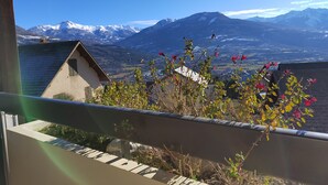 A balcony with a view of snow-capped mountains and a valley. - Résidence Calme à Proximité Immédiate D'un Sentier de Randonnée (Embrun)