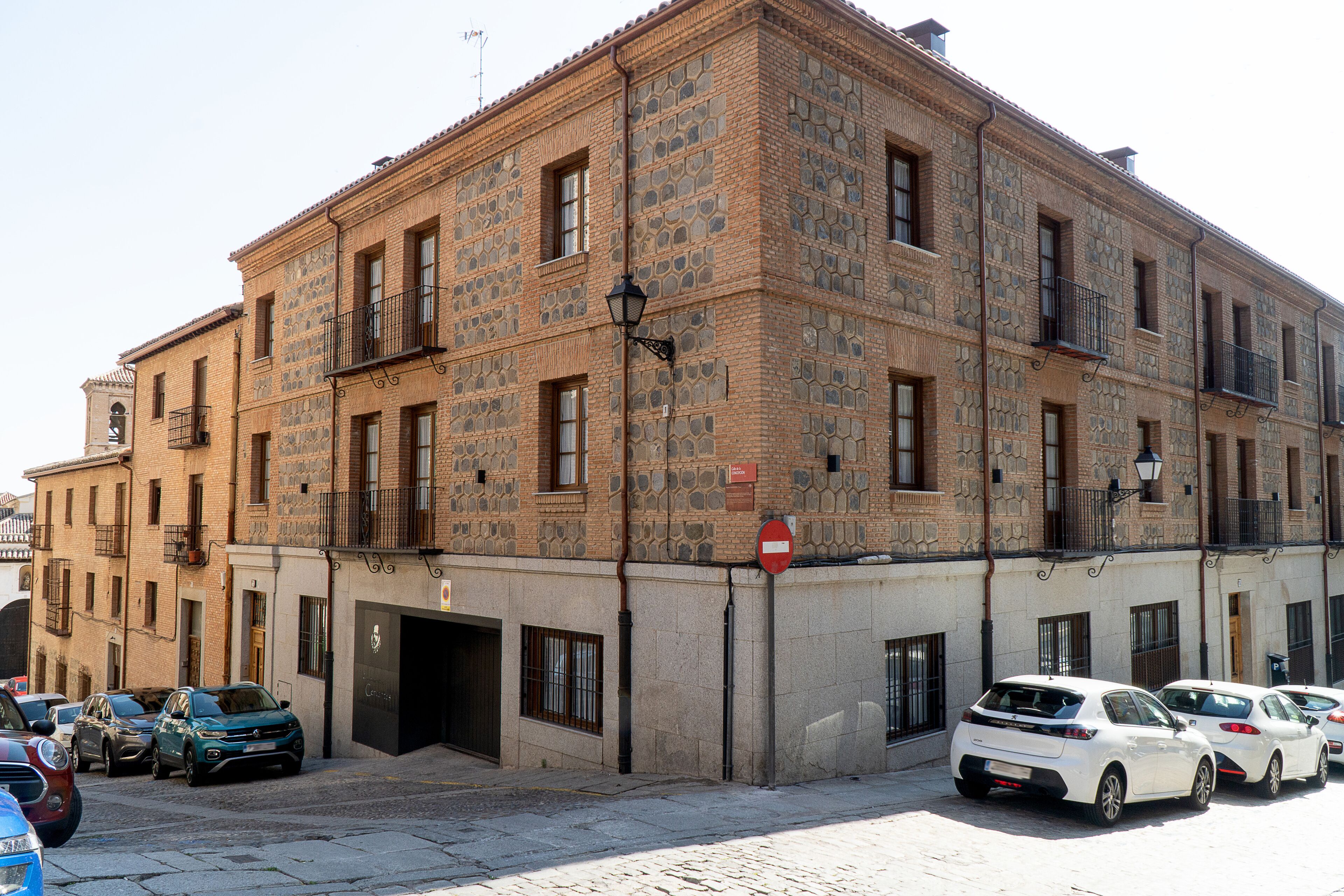 A multi-story building with a stone facade, multiple balconies, and a no-entry sign.