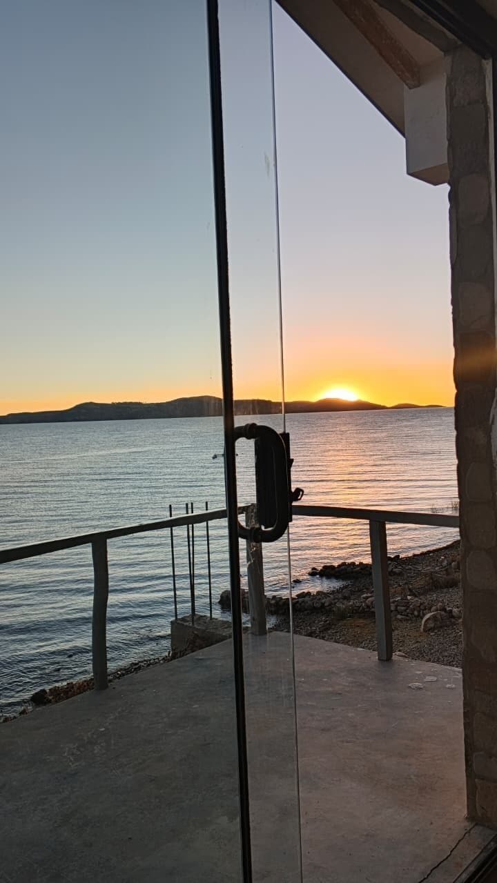 Un balcon avec vue sur la mer au coucher du soleil.