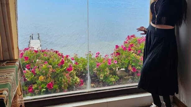 A room with a large window overlooking a body of water and distant mountains. - LUNA DEL TITIKAKA LODGE (Moon Island)