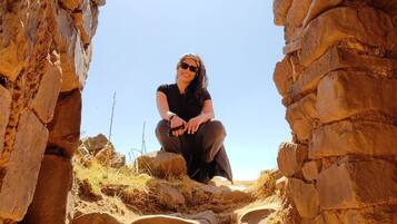 A person sitting in a stone archway.