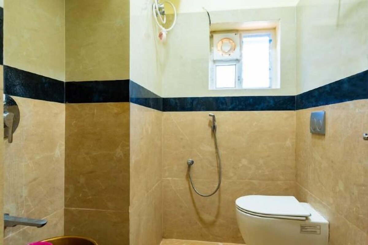 Une salle de bain avec une douche, des toilettes et une petite fenêtre.