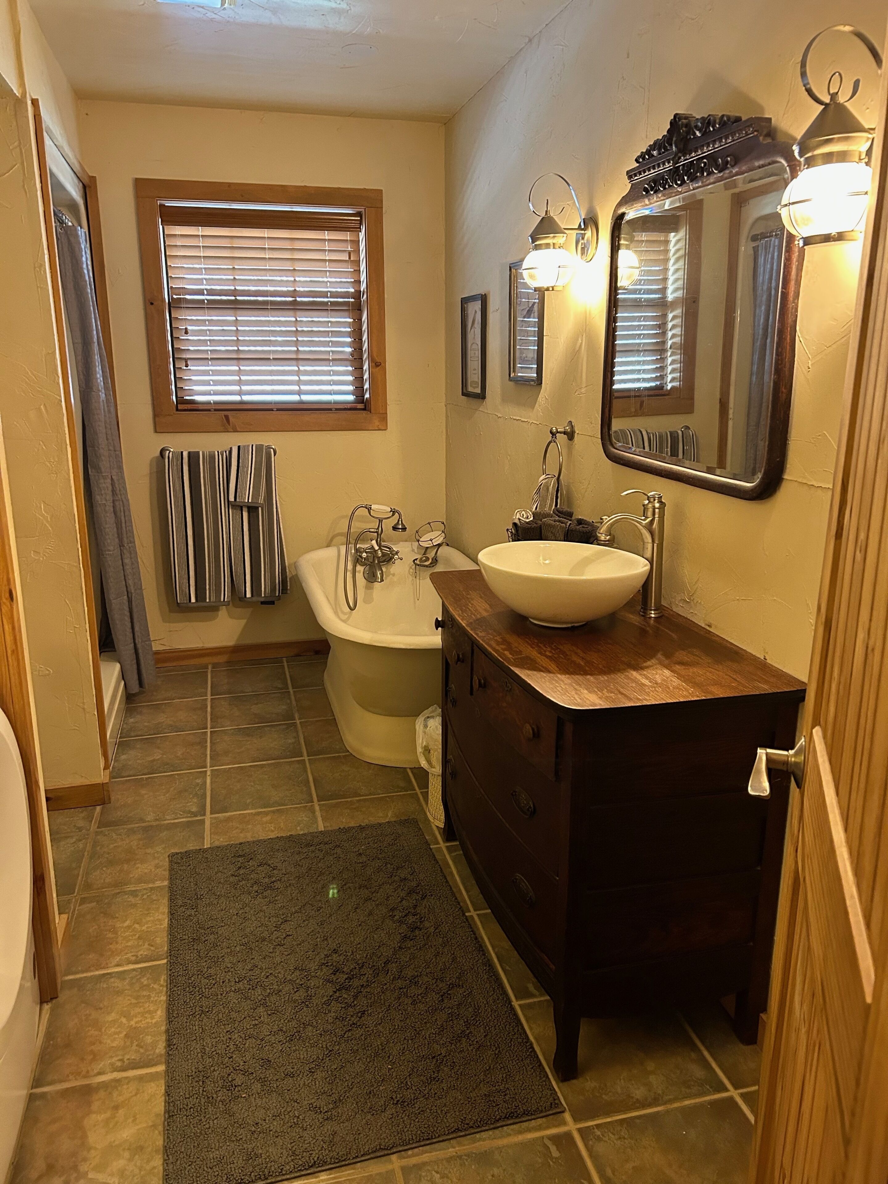 Une salle de bain équipée d’une baignoire, de toilettes, d’un lavabo et d’un miroir.