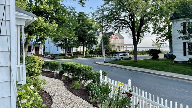 A residential street with houses, a white picket fence, and a road. - New listing! Riverside Retreat on the Choptank River (Cambridge)