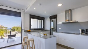Una cocina moderna con una isla grande, un ventanal y vistas de la ciudad.
