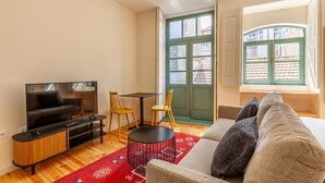A modern living room with a flat-screen TV, a sofa, a coffee table, and two chairs. - Dasi Estudio C boutique apartment (Oporto)