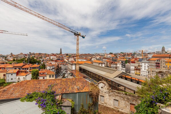 Une vue urbaine comprenant une grande grue de construction, des bâtiments historiques et une gare.