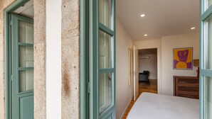 Une chambre à coucher avec un lit, une porte et un couloir menant à une salle de bain.