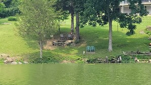 Un parco sul lago con area picnic, muro in pietra e due sedie.