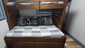 Un letto a castello con copripiumino trapuntato e cuscini con la scritta 'ON A LAKE TIME'.