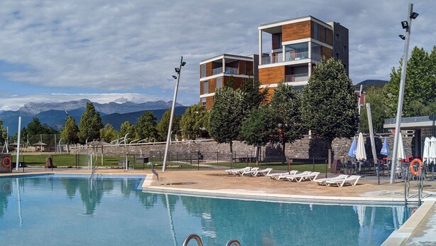 Une piscine avec des chaises longues et une vue sur les montagnes.