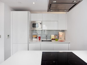 Enjoy cooking in this well-equipped kitchen with a stainless steel cooktop, sink, and ample countertop space.