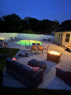 A backyard with a swimming pool, outdoor furniture, and a fire pit. - Relaxing Secluded Getaway featuring a backyard Oasis (Lower Township)