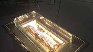 Une terrasse extérieure avec une table à plateau de verre, des chaises et une piscine en arrière-plan.