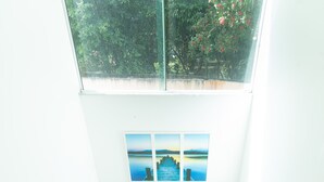 A staircase with wooden steps leading to a landing with a glass window above. - Clim House in Buzios  (Altos de Búzios Armação dos Búzios)