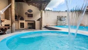 A pool area with a brick barbecue and a sign that reads "CHITZCO BAR". - Clim House in Buzios  (Altos de Búzios Armação dos Búzios)