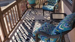 A covered outdoor seating area with patterned flooring, wicker furniture, and potted plants. - Saguaro National Park Westside retreat.   (Tucson)