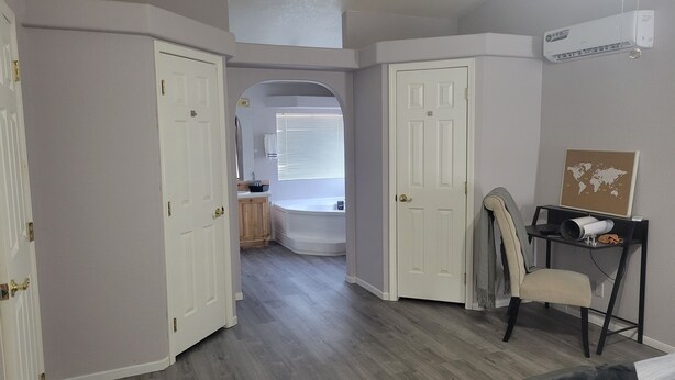 A hallway with two white doors, a black chair, a small table with a world map, and a ceiling fan. - Saguaro National Park Westside retreat.   (Tucson)