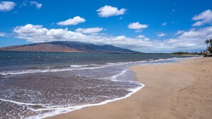 A beach with a mountain in the background and a clear sky. - Modern & Tropical Oceanside Vistas  (Kihei)