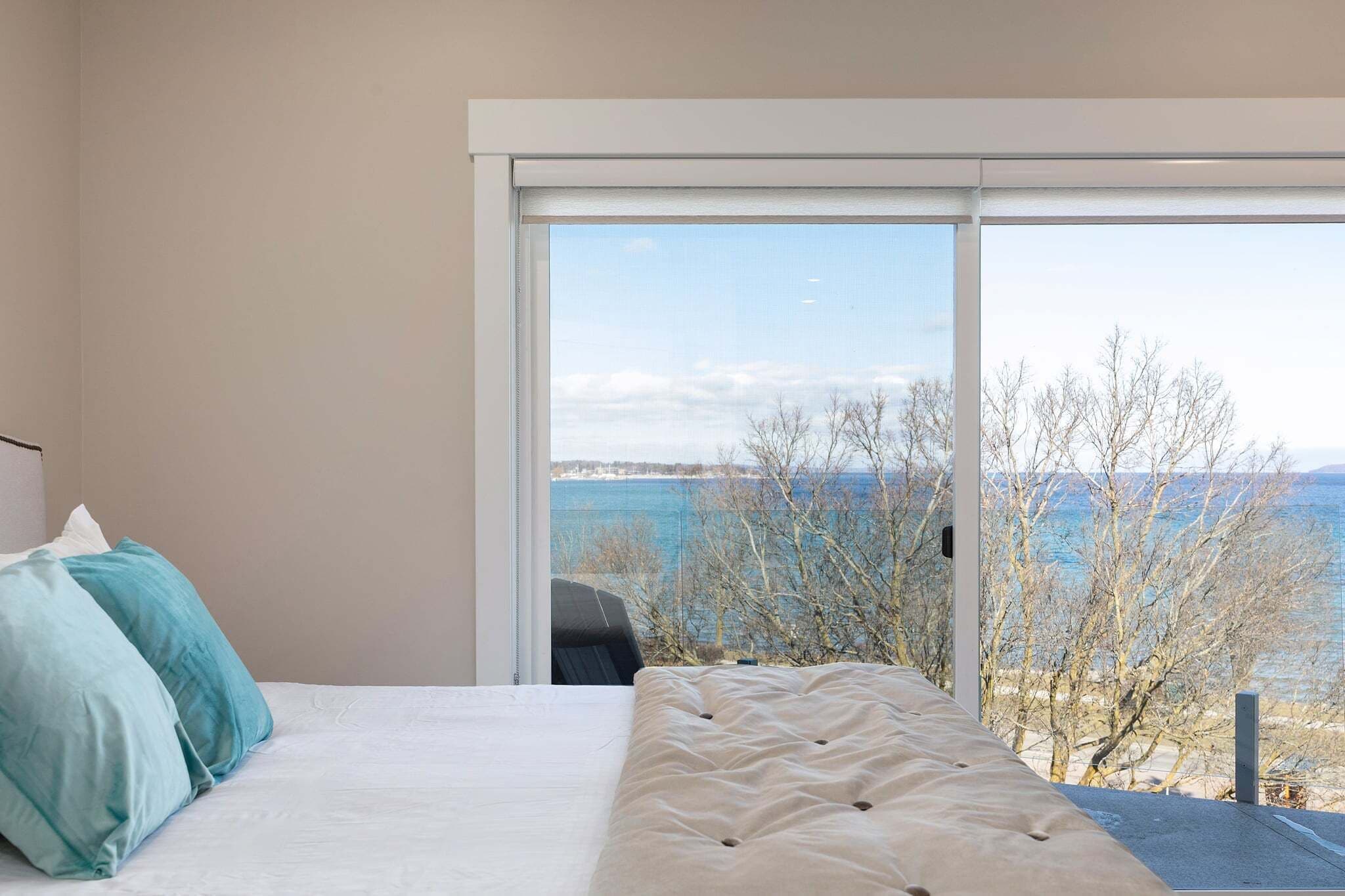 Une chambre avec un lit, une grande fenêtre et une vue sur la mer.