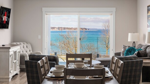 Un comedor con vistas al mar, un sofá y un televisor que muestra el logotipo de Netflix.