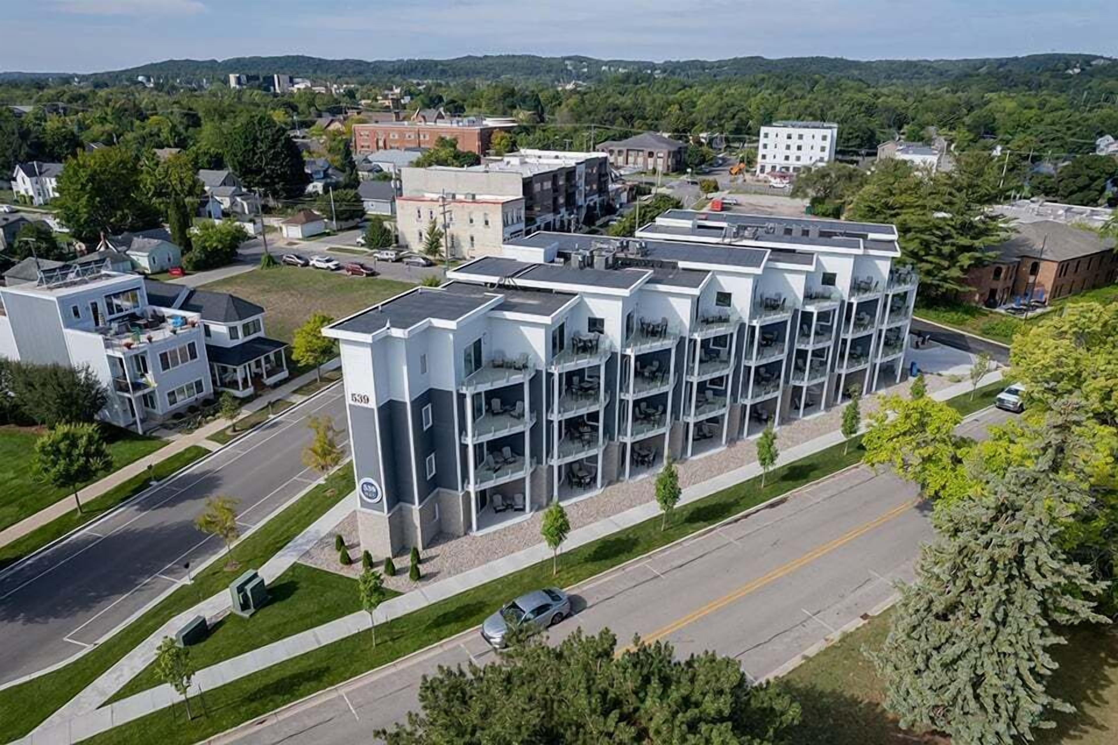 A multi-story building with a modern architectural design, featuring a central courtyard and multiple balconies.