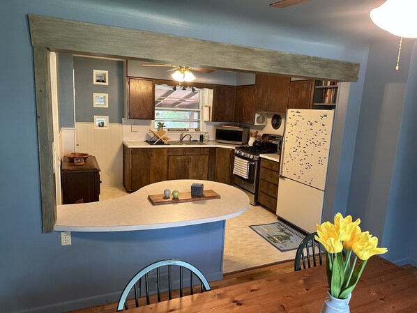 A modern kitchen with wooden cabinets, a white countertop, and a built-in oven. - Caseville cottage with beach access (Caseville)