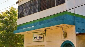 A two-story building with a sign reading "El Rio Hostel". - Hostal El Rio (León)