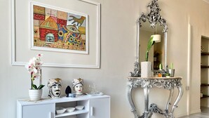 A white console table with decorative items, a mirror, and a framed painting on the wall. - Residenza Donna Peppina Tropea (Tropea)