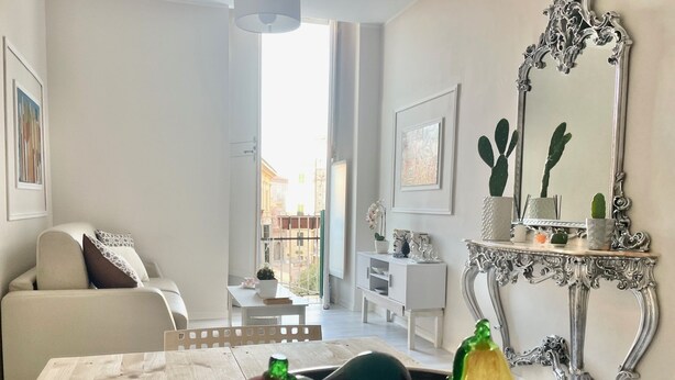 A living room with a dining table, a sofa, a decorative mirror, and a view of the outside. - Residenza Donna Peppina Tropea (Tropea)