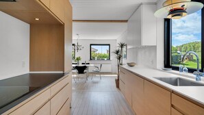 Una cucina moderna con mobili in legno, un'ampia finestra e vista all'esterno.