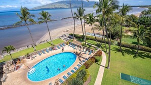 A resort with a swimming pool, beach, and palm trees. - Upscale Oceanfront Penthouse Vistas (Kihei)